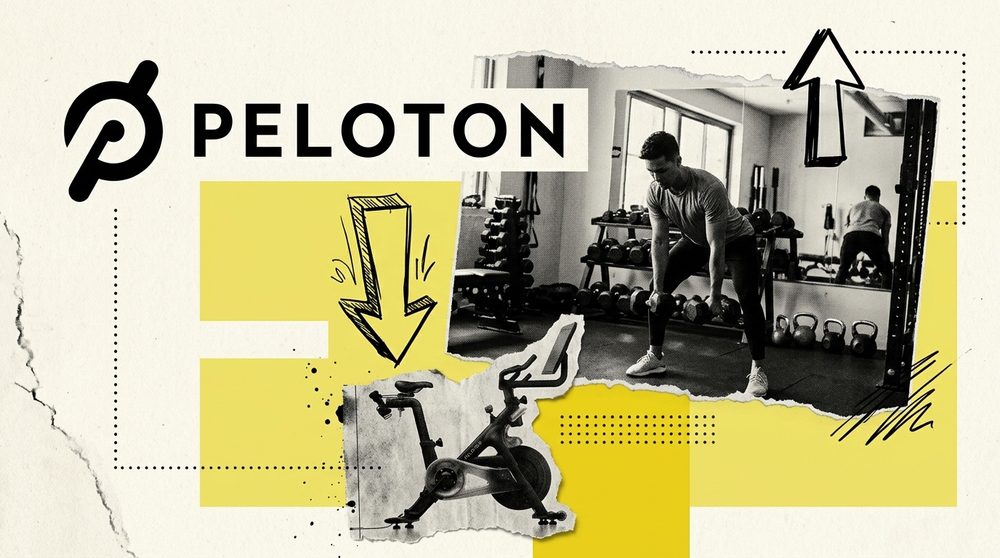 A Peloton bike in an empty room with a barbell in sharp focus in the foreground